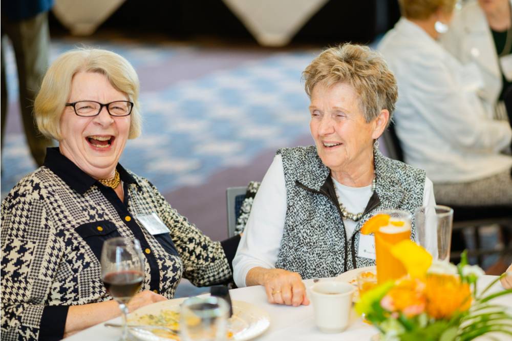 Two women laughing at the Retiree Reception.